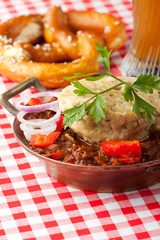 Gulasch mit Knödel auf rot karierter Tischdecke
