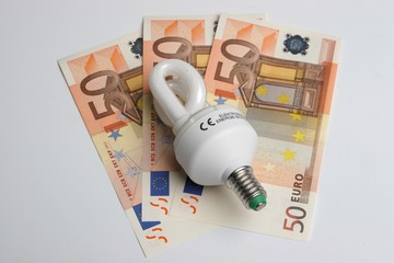 Energiesparlampe mit Geldscheinen