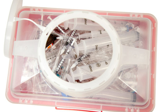 Syringes and pipets in a sharps container.