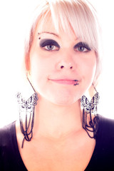 Eine Frau mit Schmuck und Piercing im Gesicht lächelt breit
