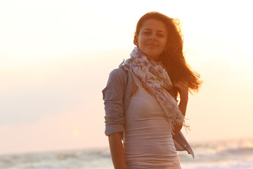 Obraz premium young attractive woman on sunset sea background