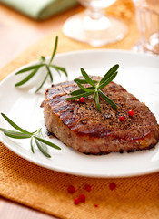Beefsteak with rosemary and peppercorns on a plate