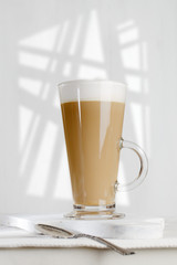 coffee latte with frothy milk in tall glass