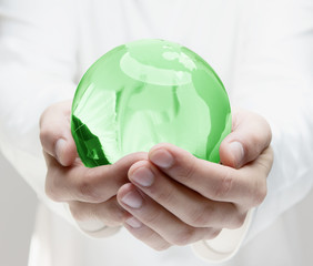 Human hands holding green earth