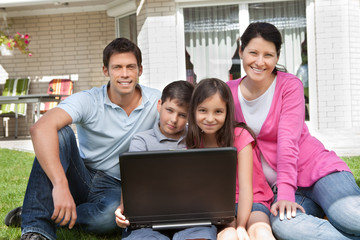 Happy family sitting together with laptop
