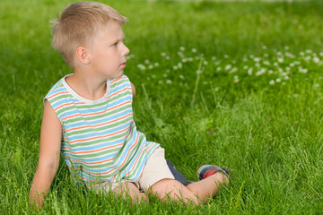 Fototapeta premium Boy on the grass looking aside