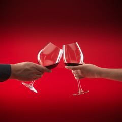 couple holding glasses of red wine toasting