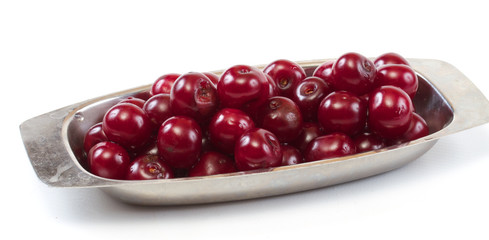 Bowl with ripe cherries. Isolated on a white background.