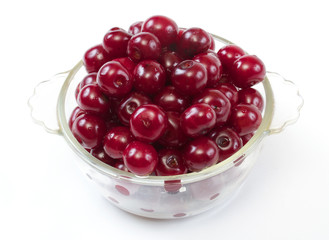 Bowl with ripe cherries. Isolated on a white background.