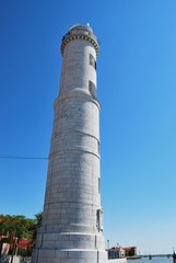 White lighthouse on Murano island in a sunny day, Venice, Italy