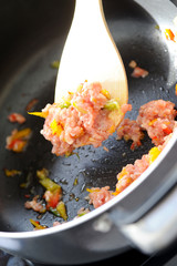 Pork grinds raw food in pan