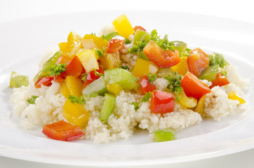 Couscous mit drei verschiedenen Paprikasorten auf einem Teller