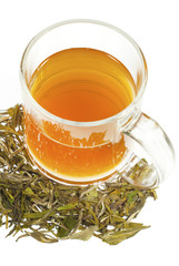 tea in glass cup and dried leaves