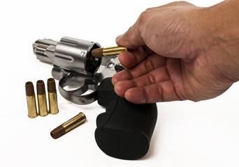 Put bullet into revolver gun isolated on white background