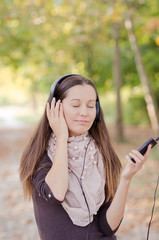 Beautiful Girl listening music outdoor with her cell phone