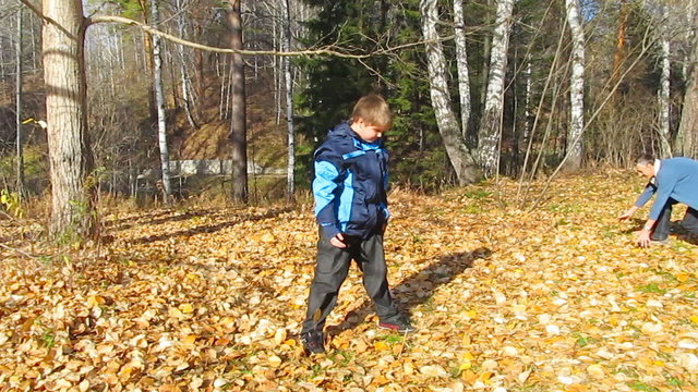 father and son playing with leaves