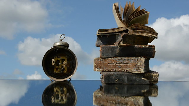 old books and vintage clock on mirror and wind