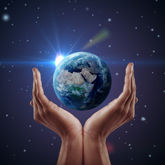 Hand holding earth. Night background, shining