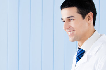 Portrait of happy smiling young doctor at office