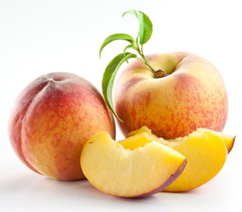 Ripe peach fruit with leaves and slises