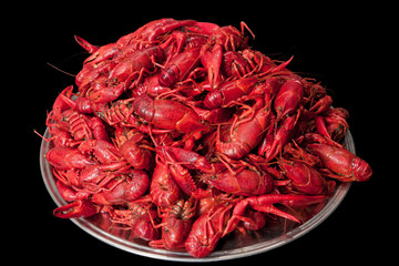 Many cooked and stacked crayfish, isolated on black background