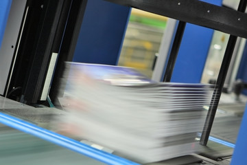 Druckexemplare verlassen eine Umreifungsanlage