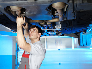Engine repair on a service lift in a garage with motor mechanic