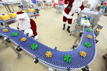 santa claus at christmas ornament production line in factory