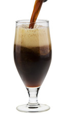 Alcohol dark beer with froth being poured into a glass isolated.