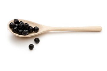 Black chokeberry in a spoon isolated on the white background