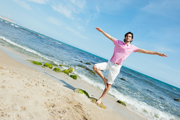 Portrait of young man standing carefree with outstretched arms o