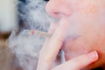 smoking joint closeup with smoke