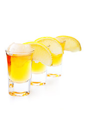 Gold Tequila with lime slice isolated on white background
