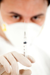Doctor in a mask with a syringe