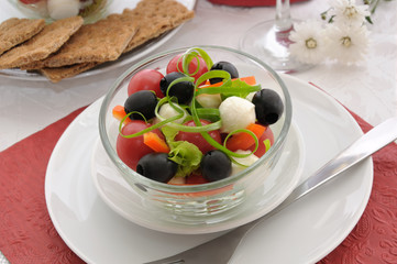 Salad of lettuce, cherry tomatoes, olives and mozzarella with pe