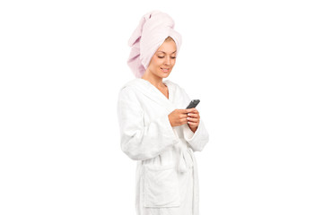 A young woman in bathrobe holding a mobile phone