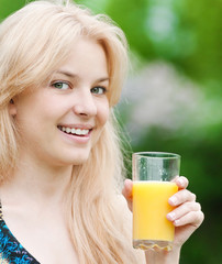 Smiling woman drinking orange juice