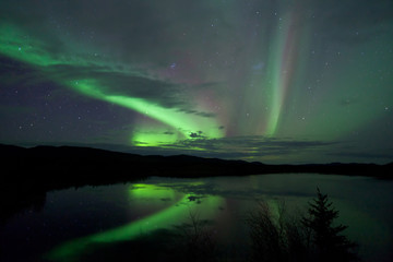 Stars and Northern Lights over dark Road at Lake