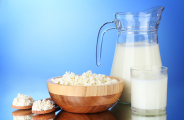 Tasty milk and cottage cheese on  blue background