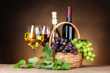 Bottles of wine, glasses and grapes in basket