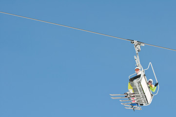 Ski lift - happy skiers on ski  vacation (copy space)