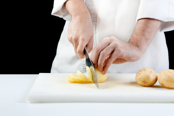 Obraz na płótnie Canvas Chef cutting potatoes