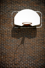 Basketball Hoop With Missing Net on Brown Brick Wall