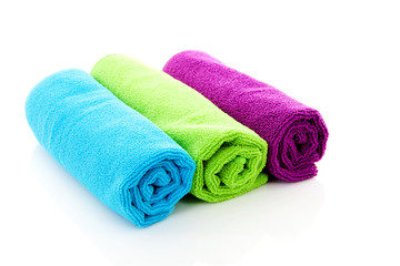 Three colorful rolled towels over white background