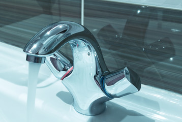 stainless steel modern faucet inside beautiful bathroom