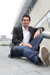 Businessman sitting in stairs out in town