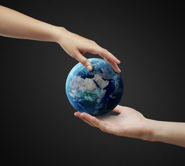 Male and female hand holding earth