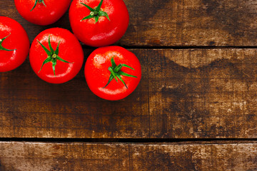 Ripe red tomatoes on rustic wooden background