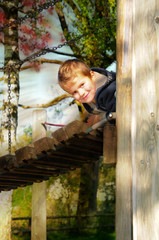 Obraz na płótnie Canvas Chłopiec patrzy z drewnianego mostu