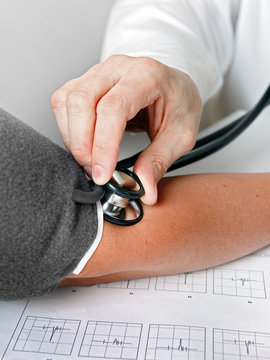 Arzt misst den Blutdruck und Puls bei Patientin